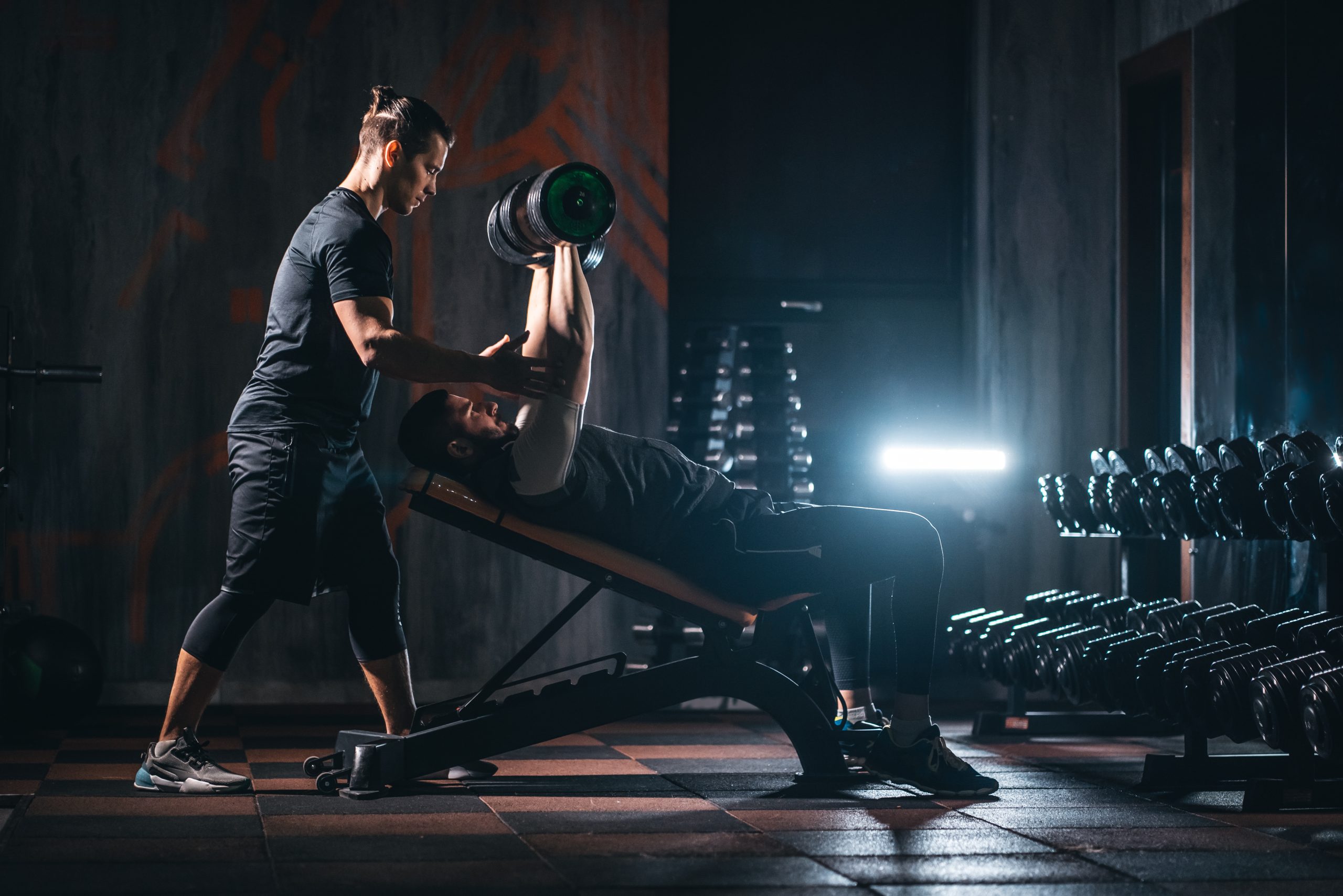 young man has workout with personal trainer in modern gym sportovec scaled - Vodíková voda